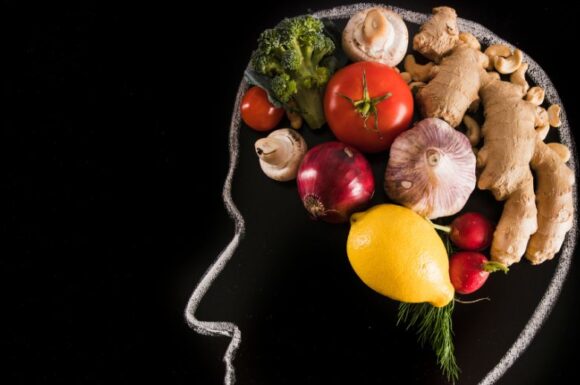 Cervello umano con all'interno alimenti vari, simbolo del legame tra nutrizione e salute, in riferimento alla laurea in Scienze della Nutrizione Umana