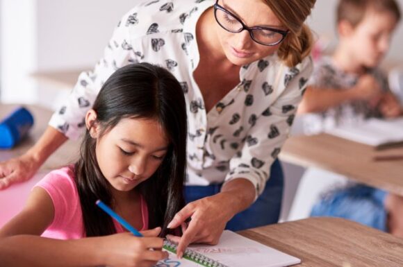 TFA Sostegno 2025: docente dopo il percorso di specializzazione sul sostegno che lavora con una studentessa in aula.