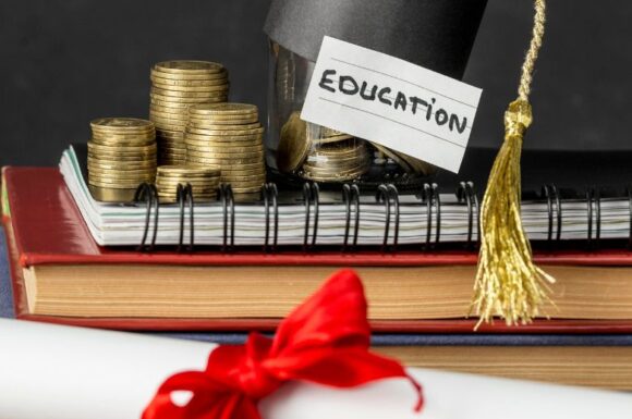 Vari elementi quali pergamena, libri, tesi, monete, simboli della Laurea in Economia